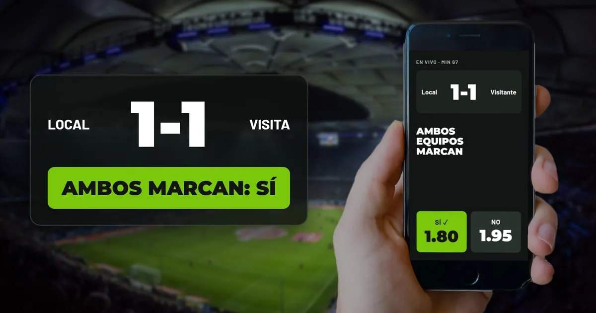 Mano con un celular que muestra el marcador 1-1 y la apuesta ambos marcan Sí a cuota 1.80, frente a un estadio de noche