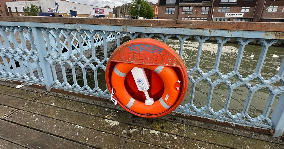 Salvavidas naranja colgado en la baranda de un muelle