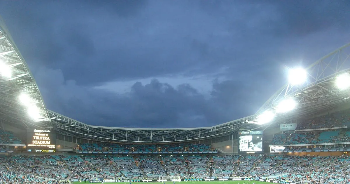 Estadio de fútbol lleno con las luces encendidas durante un partido